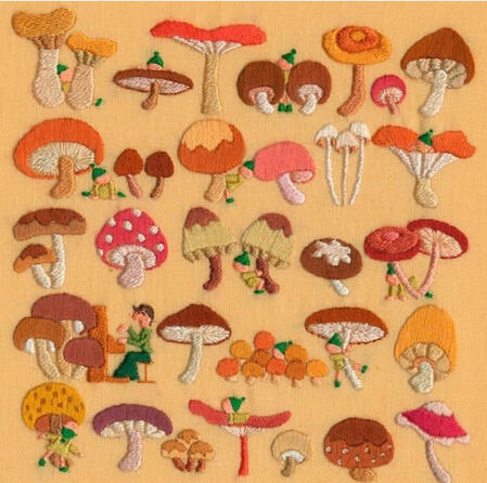 an image of several orange, brown, peach, and red mushrooms embroidered on a light orange piece of fabric.